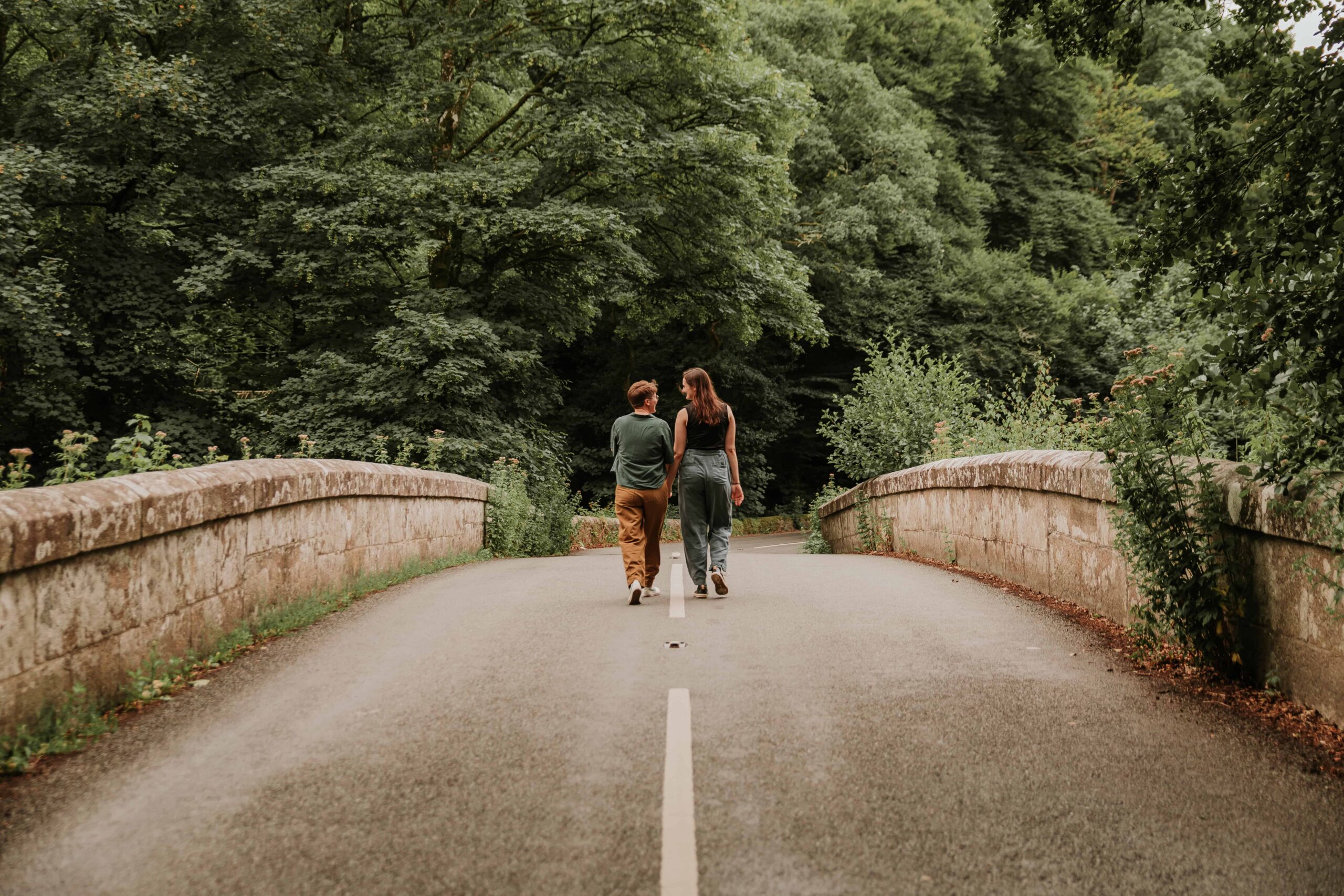 couple standing in the middle of a bridge at surprise proposal
