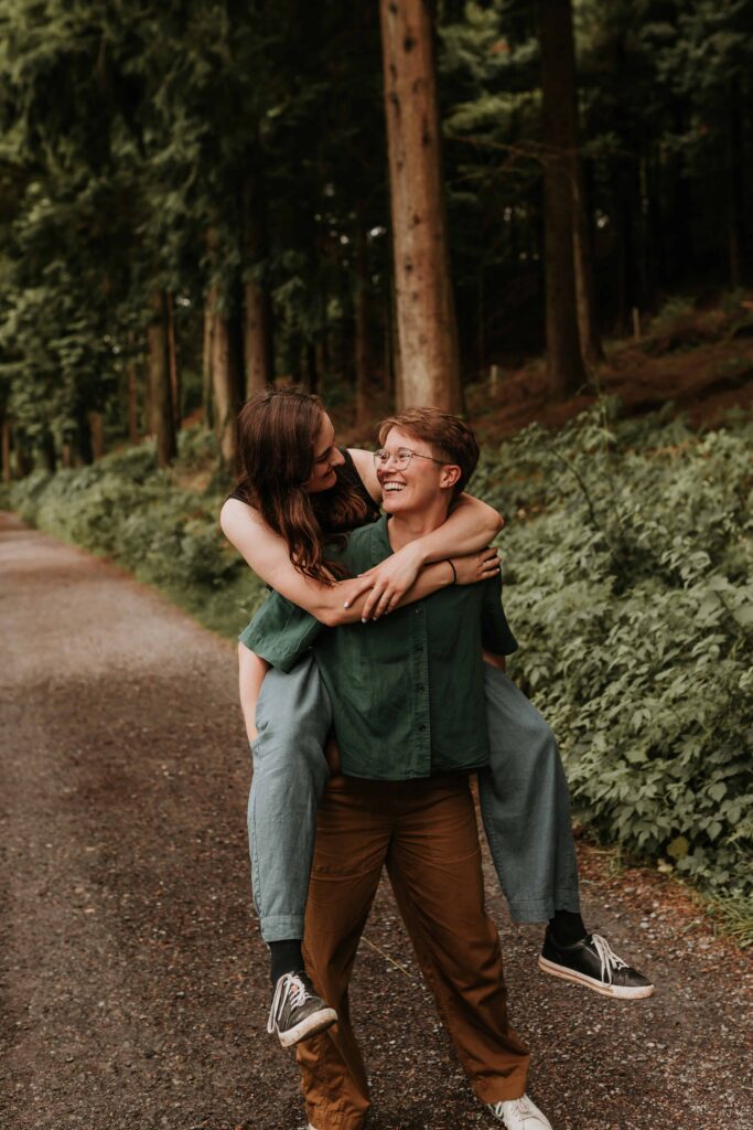 couple having a piggy back in devon woodland