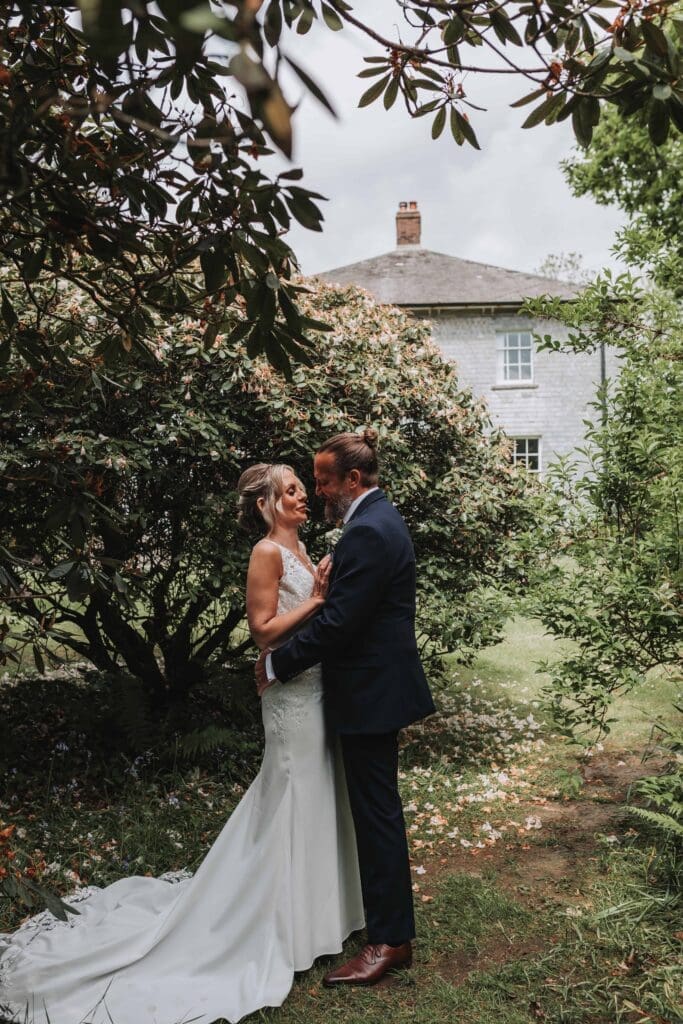 bride and groom with treseren house in the background