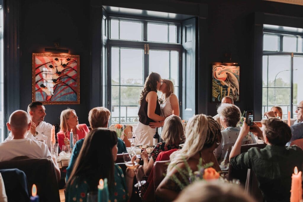 two brides kissing at wedding reception