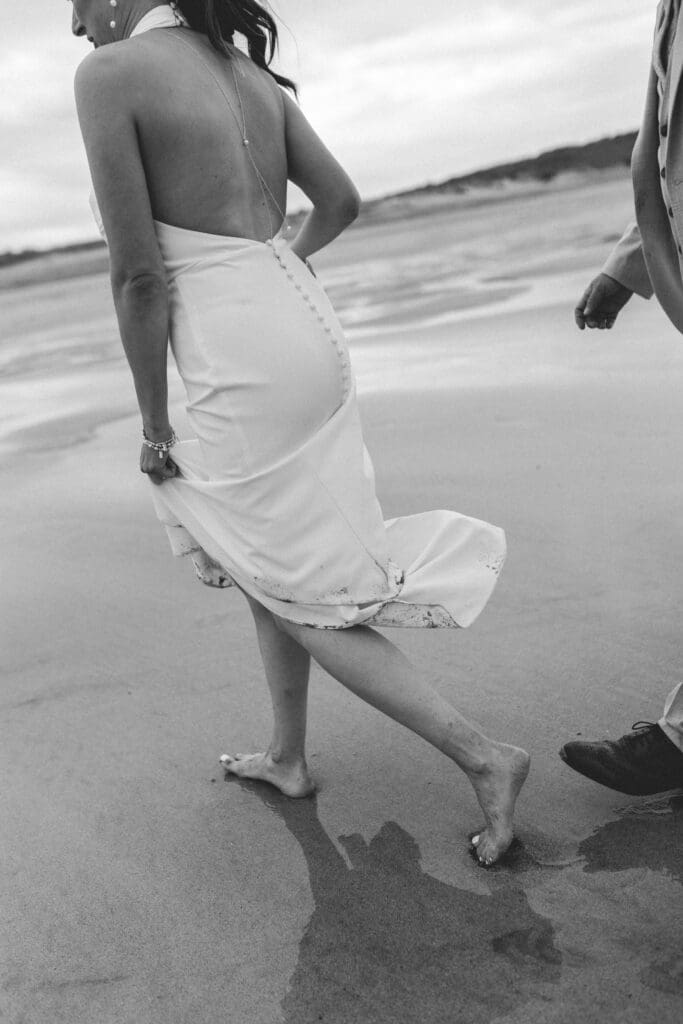 groom chasing bride on the beach