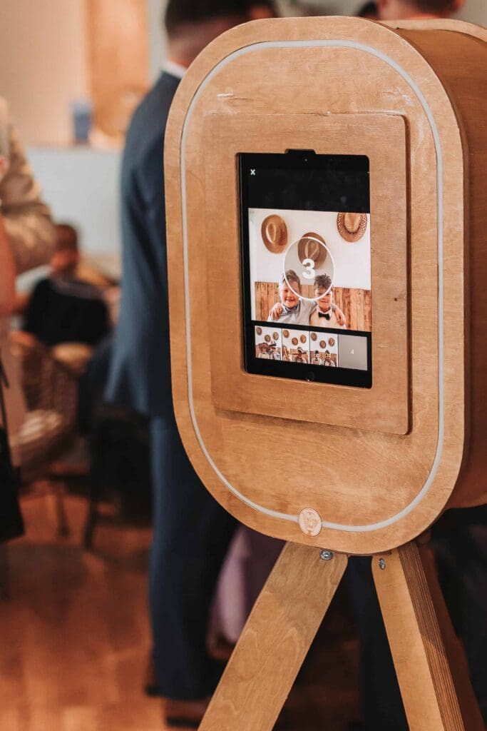kids using photobooth at beachside wedding