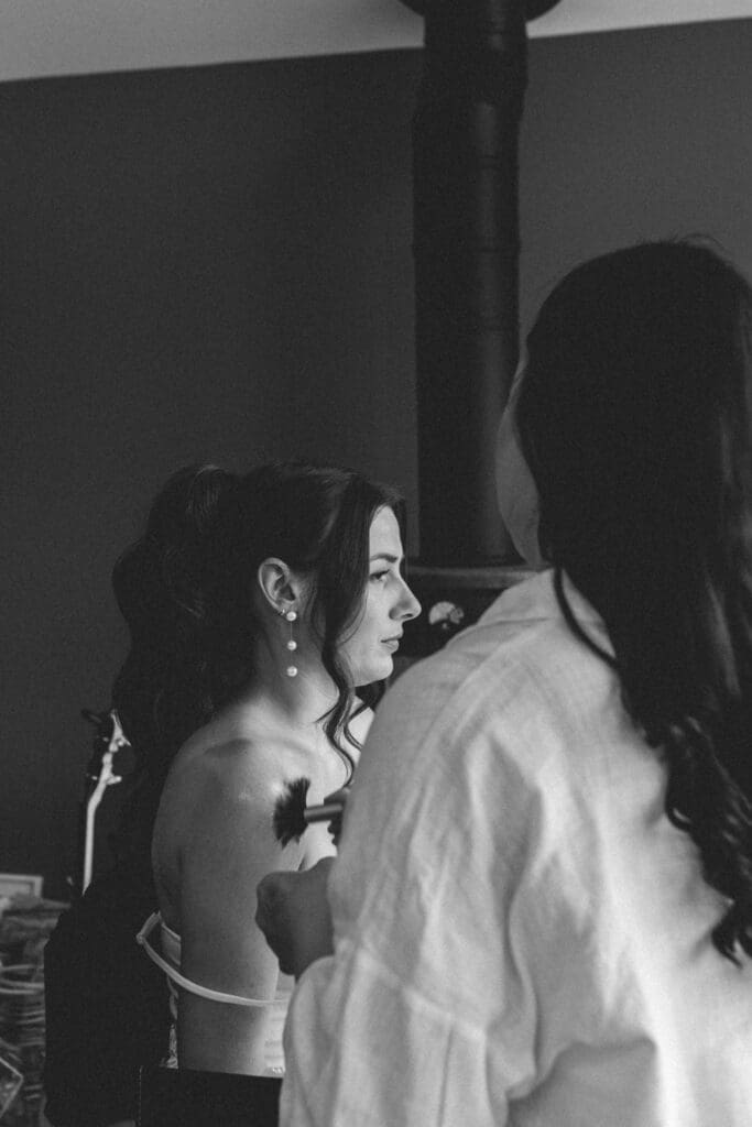 bride having shimmer put on shoulders