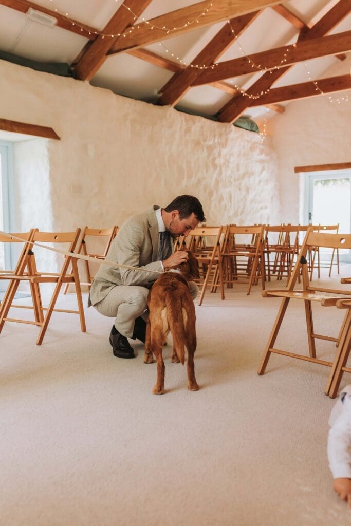 groom cuddling dog in wedding aisle after choosing to elope in the uk