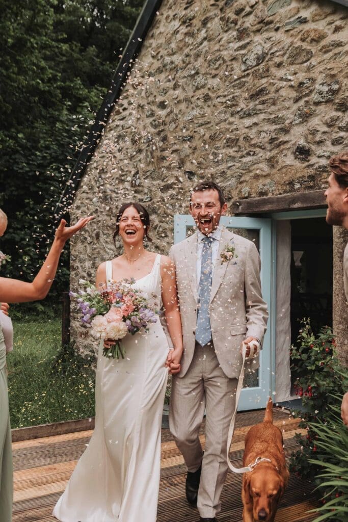 bride and groom walking through confetti after deciding to elope in the uk