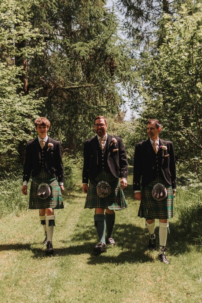 groom and best men walking through woodland