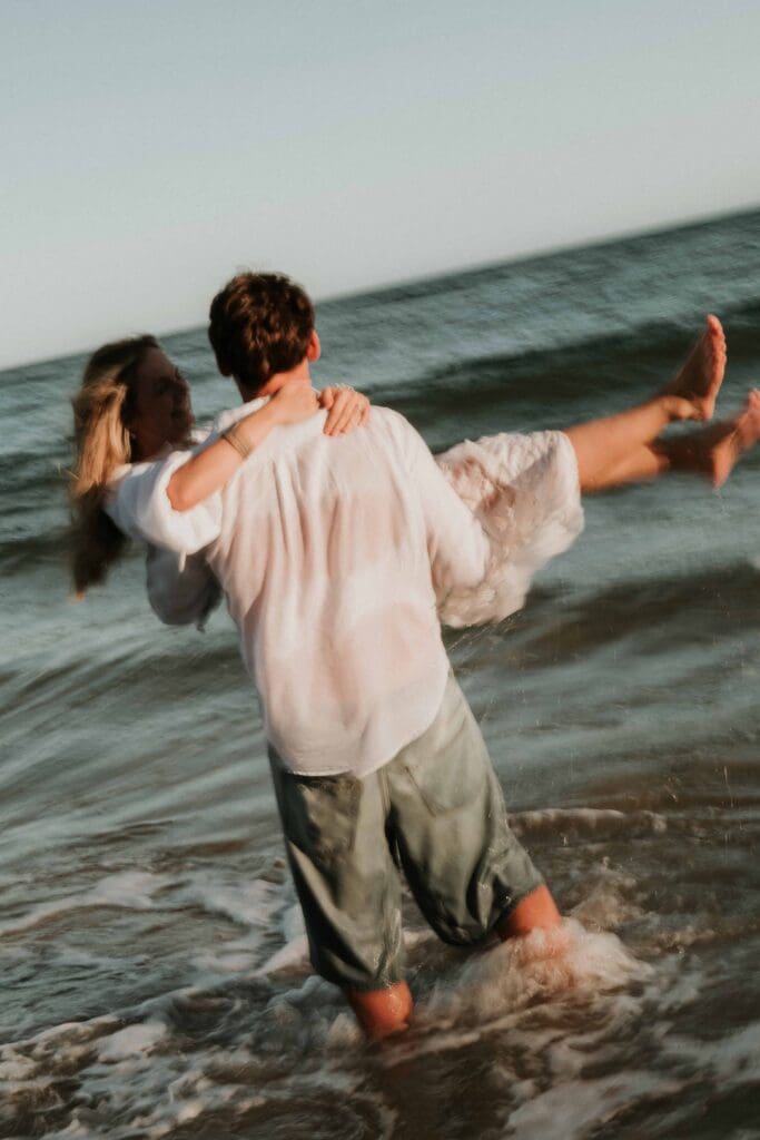 guy carrying girl through the sea