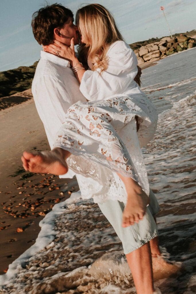 guy holding up girlfriend under her legs and back