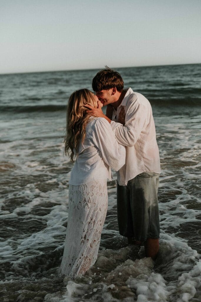 girl and guy kissing in the sea at beach couple photoshoot