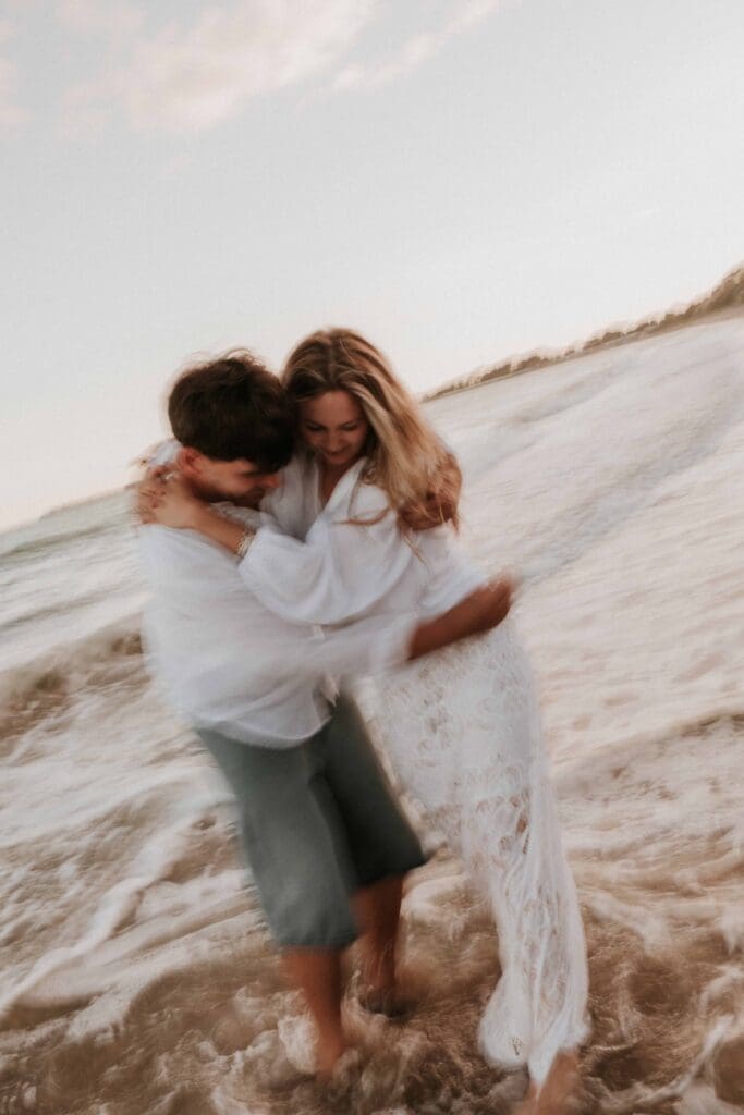 guy and girl holding each other at beach couple photoshoot