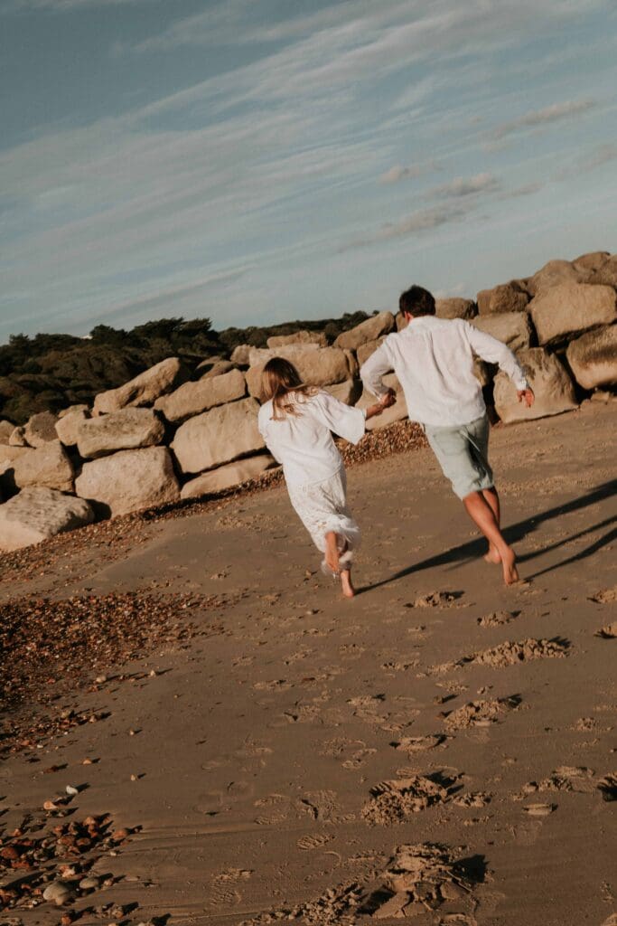 girl and guy running along the beach