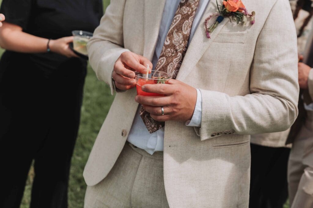 groom holding frozen cocktail