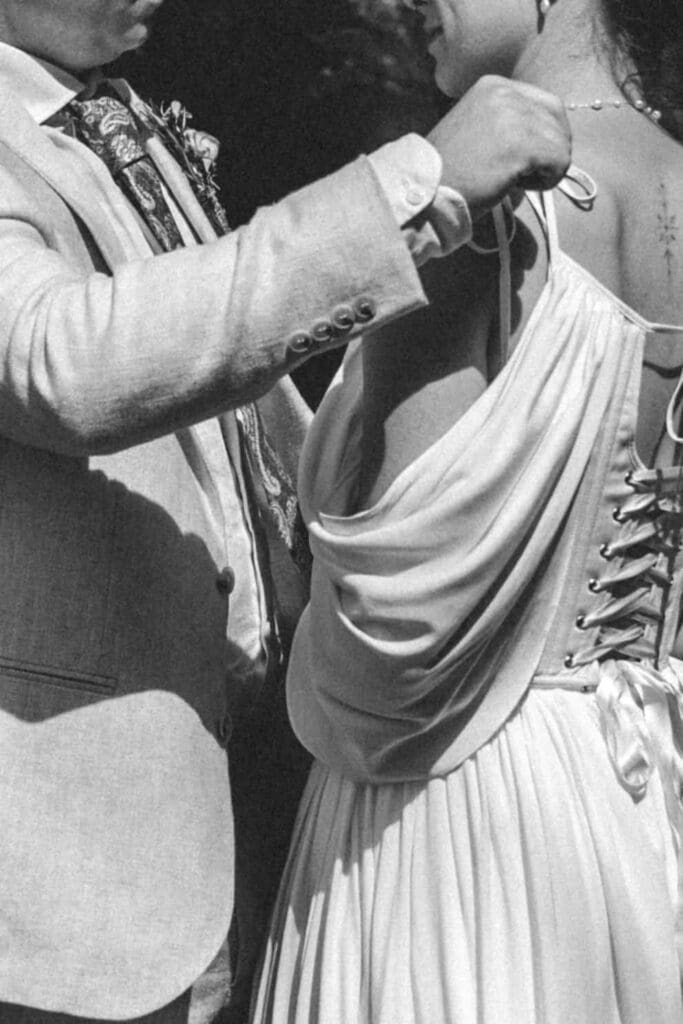 groom adjusting brides dress strap