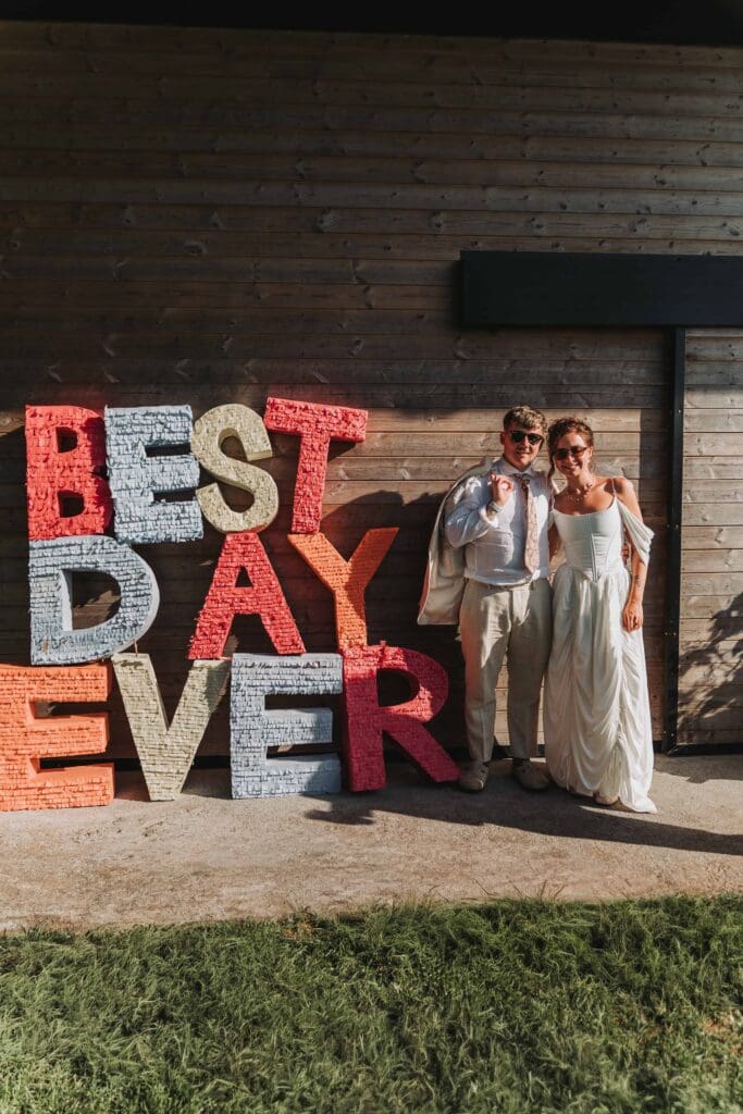 bride and groom next to best day ever sign
