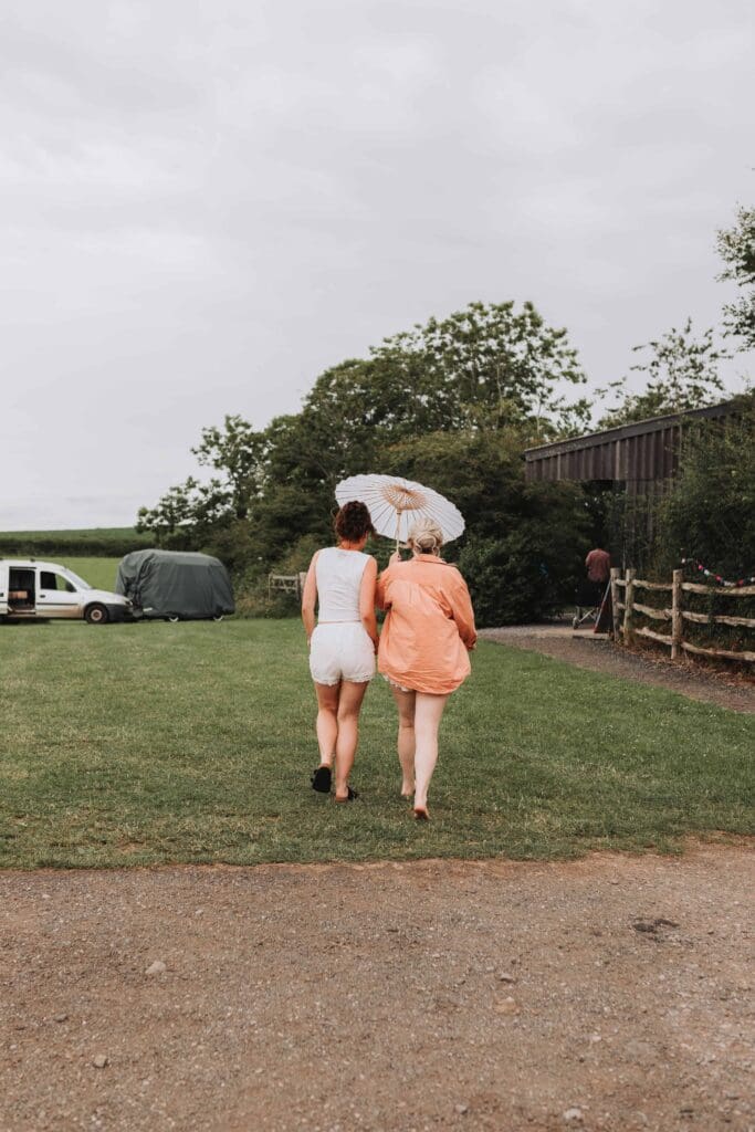 bride and bridesmaid under umbrella
